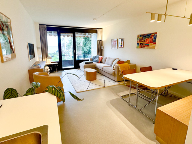 Lichtdurchfluteter Wohnbereich mit Sofa und Meerblick durch die Balkontür